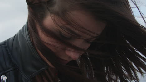 chica triste mirando hacia abajo con el pelo desordenado en el viento