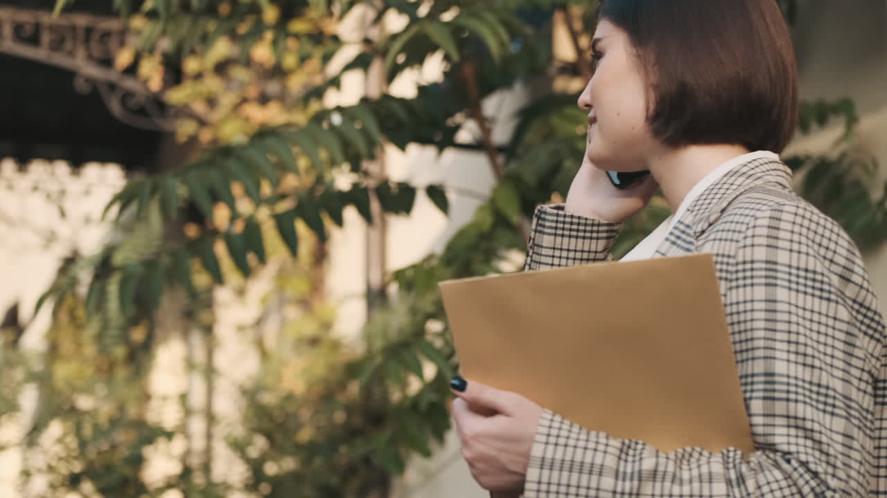 una mujer elegante haciendo una llamada de negocios al aire libre.