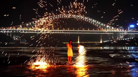 escena nocturna feliz joven mujer asiática bailando y jugando a los fuegos artificiales juntos bajo el puente en la celebración de vacaciones fiesta evento
