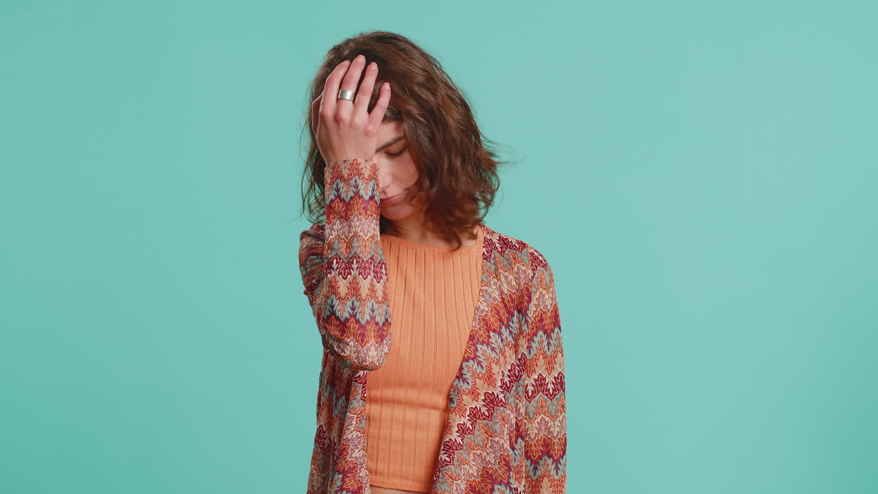 Young woman making face palm gesture feeling bored disappointed in result bad news sorrowful