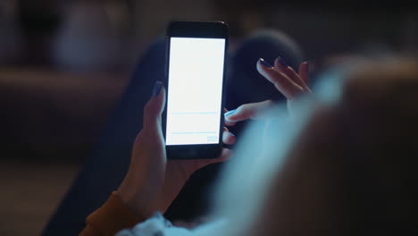 woman reading document late at night at home on smart phone