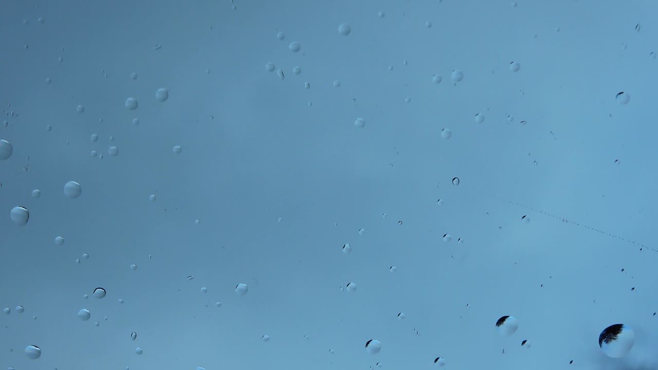 vista de cerca de las gotas de lluvia que caen sobre una superficie de vidrio