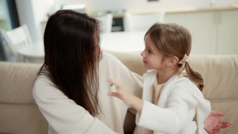 Glückliche-Mutter-Und-Kleine-Süße-Tochtergesichter,-Gesehen-Durch-Verbundene-Finger,-Die-Herzform-Bilden