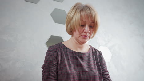 middle-aged lady in checkered dress focused on task, standing near a decorated mirror wall, modern and stylish interior creating a serene ambiance with soft lighting