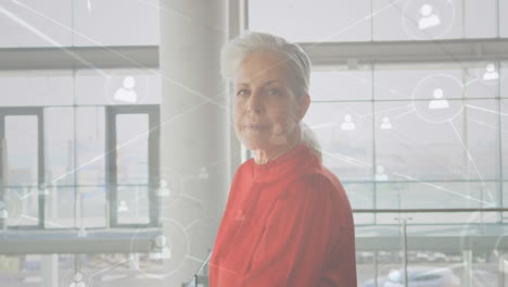animación de una red de iconos de perfil contra el retrato de una mujer anciana caucásica sonriendo en la oficina