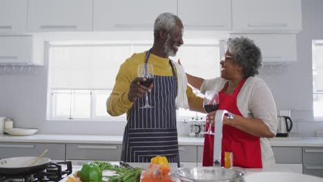 una pareja mayor afroamericana cocinando en casa. distanciamiento social en cuarentena