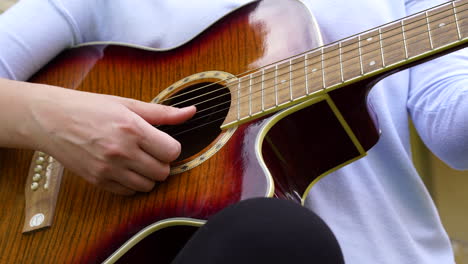 a closeup with a guitar played by a woman