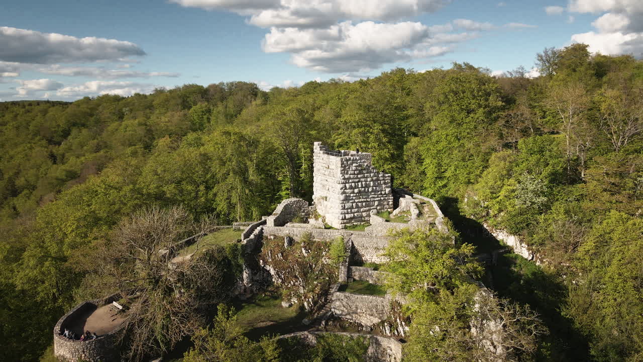 Dinamica orbita in 4K UHD di un drone intorno alle rovine del castello di Hohengundelfingen, sopra la valle del Lauter, che rivela le dolci colline del Giura Svevo, le foreste e i cieli azzurri.
