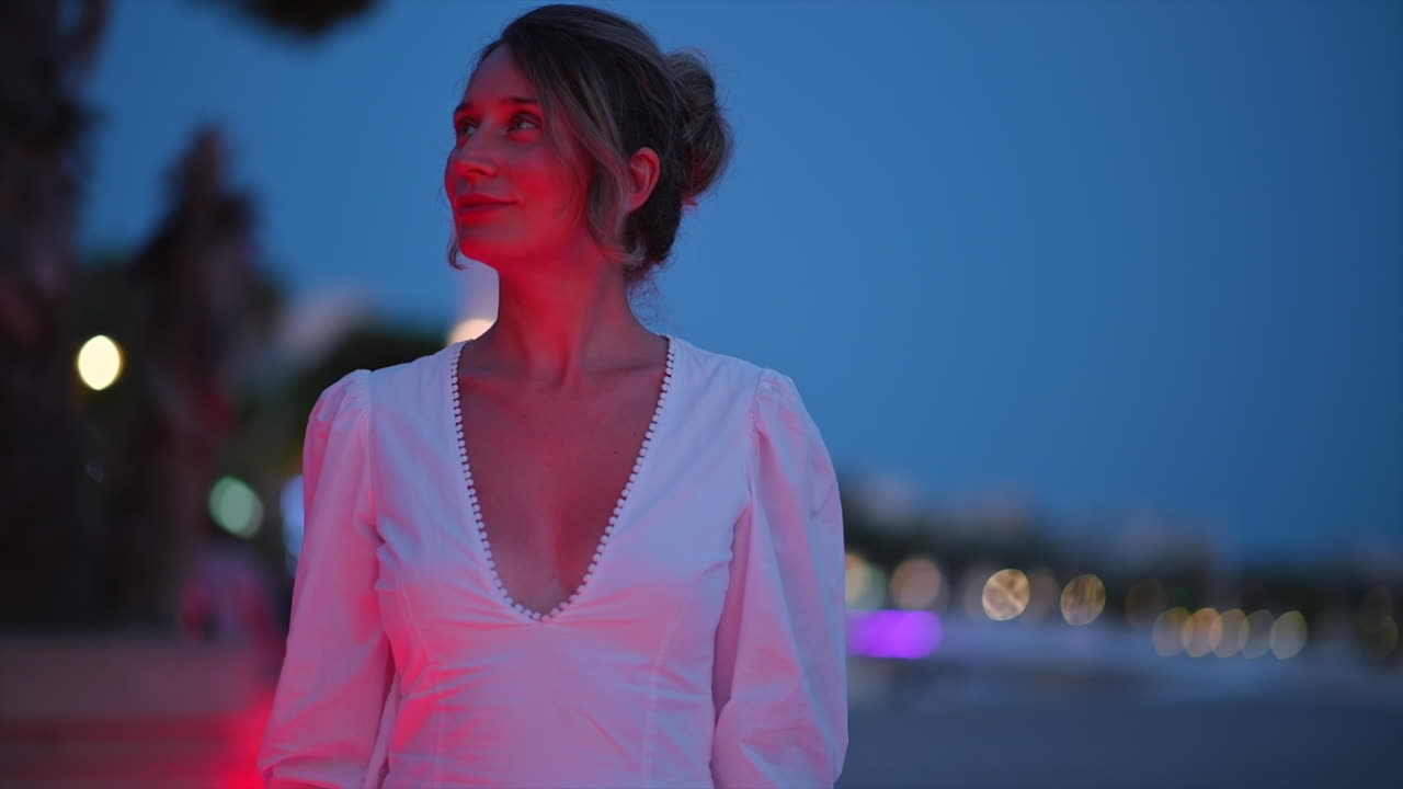 Donna in abito bianco che cammina per la strada del lungomare di Cannes, Francia