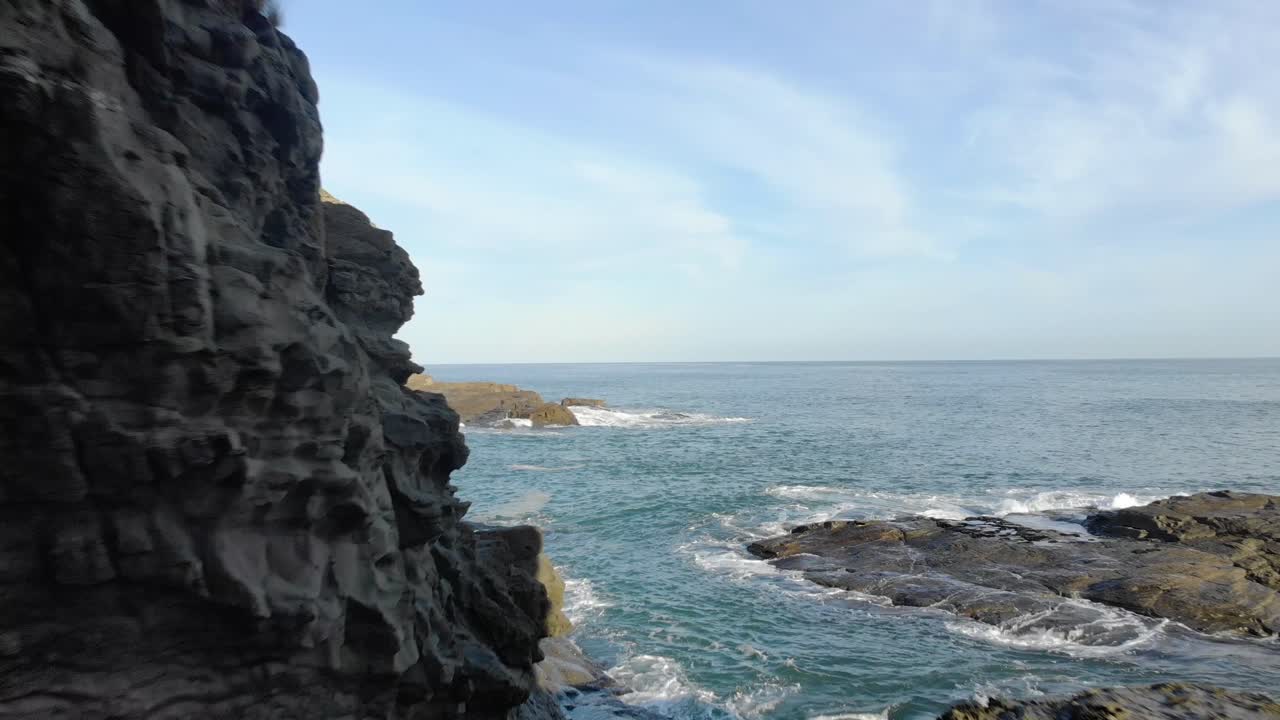 Aerial shot flying through an arch on the southern coast of Australia towards a blue ocean