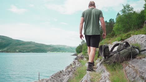 Backpacker-At-The-Rocky-Shore-With-His-Dog-Pet-During-Summer