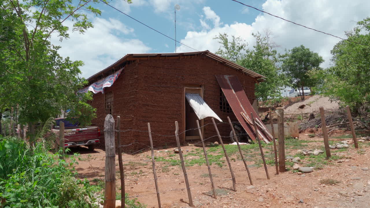 Rustic adobe-style house with a pickup truck in a rural setting