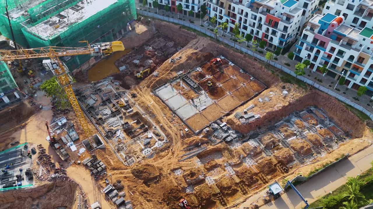 Drone shot of the construction site for the VinHomes resort on Phu Quoc Island, Vietnam. The site shows ongoing work on buildings modeled after Santorini architecture, with cranes and machinery.