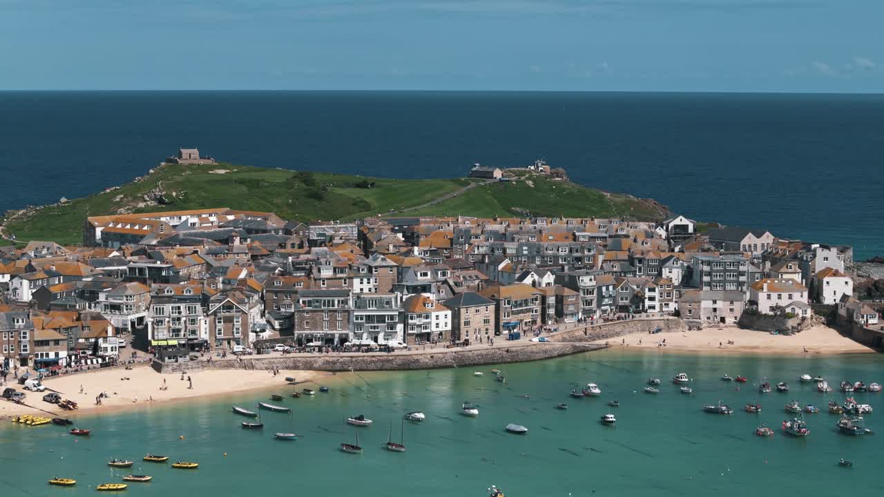 Bayfront circle right drone shot of boats moored along vibrant St Ives shoreline