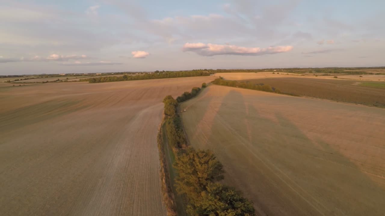 desplazamiento lento de 360 grados para mostrar un paisaje abierto de tierras de cultivo que termina con una toma de una hermosa puesta de sol de verano