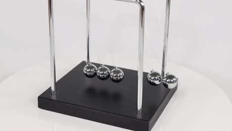 a detailed look at the motion of spheres in a newton's cradle on a black base.