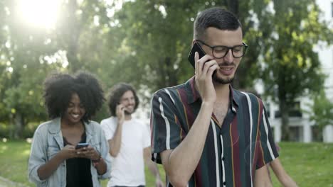 Cheerful-bearded-guy-talking-on-smartphone