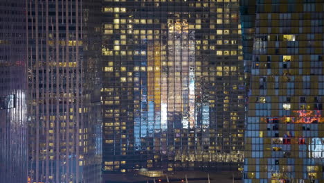 illuminated facades of modern skyscrapers at night