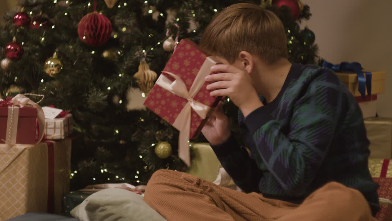 Boy with gifts near the Christmas tree