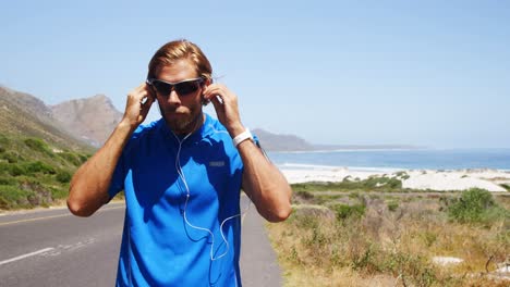 triathlete man wearing earbuds in the countryside road