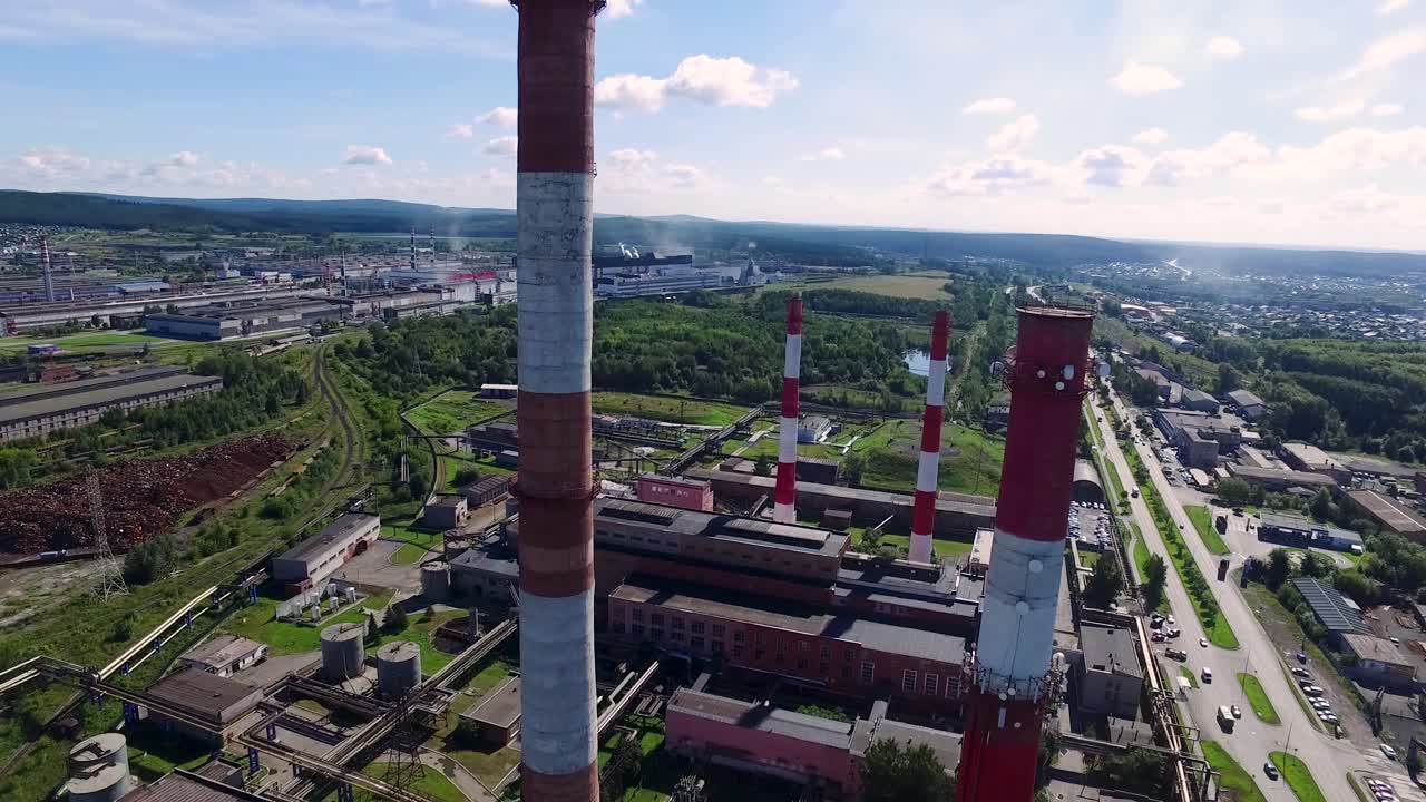 воздушный вид промышленного комплекса с дымоходами и окружающим ландшафтом