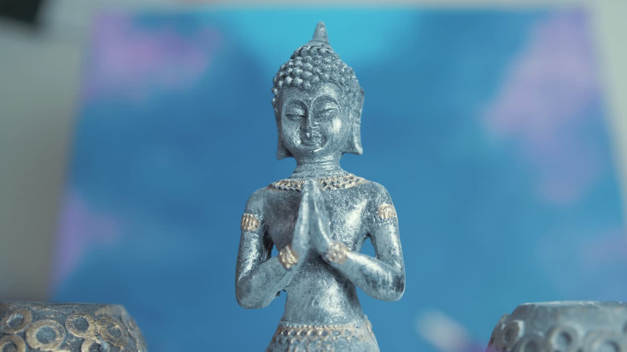 Incense burns in front of Buddha statue. Slider shot track in