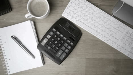 Calculator falling on office desk in black and white