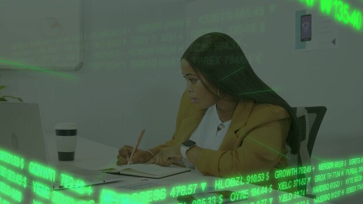 Donna che guarda il laptop, poi prende appunti, tocca il telefono, con un ticker verde in sovrimpressione, analizzando i dati di mercato.