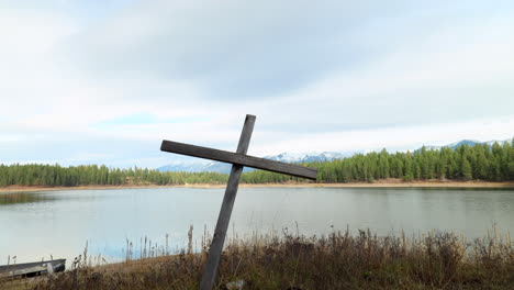 motion controled timelapse of a wooden cross on the shore of a beautiful lake in the mountains of montana on a sunny day