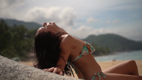 sexy young woman relaxing on the beach wearing a bikini - slow motion