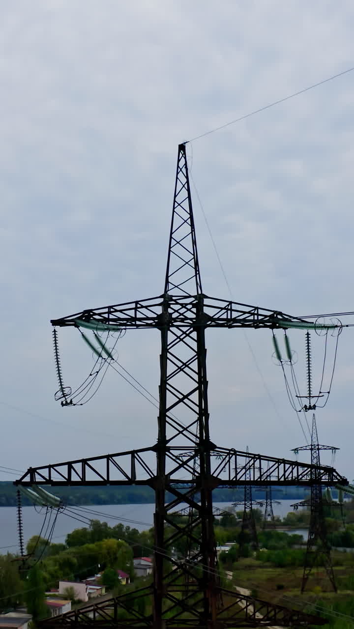 Electric poles under blue sky. High voltage transmission towers for supplying electricity. Vertical video