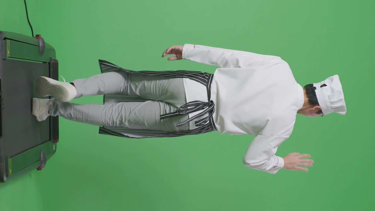 뒷모습으로 가득 찬 몸, 아시아 남성 요리사, 트레드밀에서 고, 녹색 스크린 배경 스튜디오에서 손을 흔들고