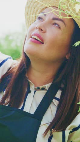 a focused gardener: a close-up view of a woman with a straw hat engaging with nature and showing care and passion for her plants