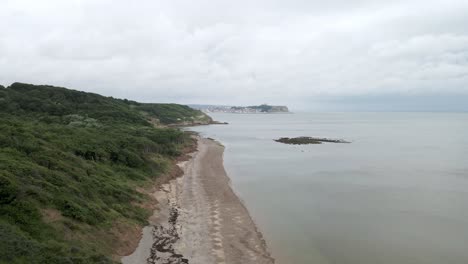 Aerial-reveal-shot-of-Scarborough-from-afar,-North-Yorkshire-on-a-cloudy-day