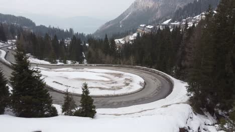 revealing-shot-of-skiing-hotel-resort-in-mountains-showing-twisted-snowy-roads