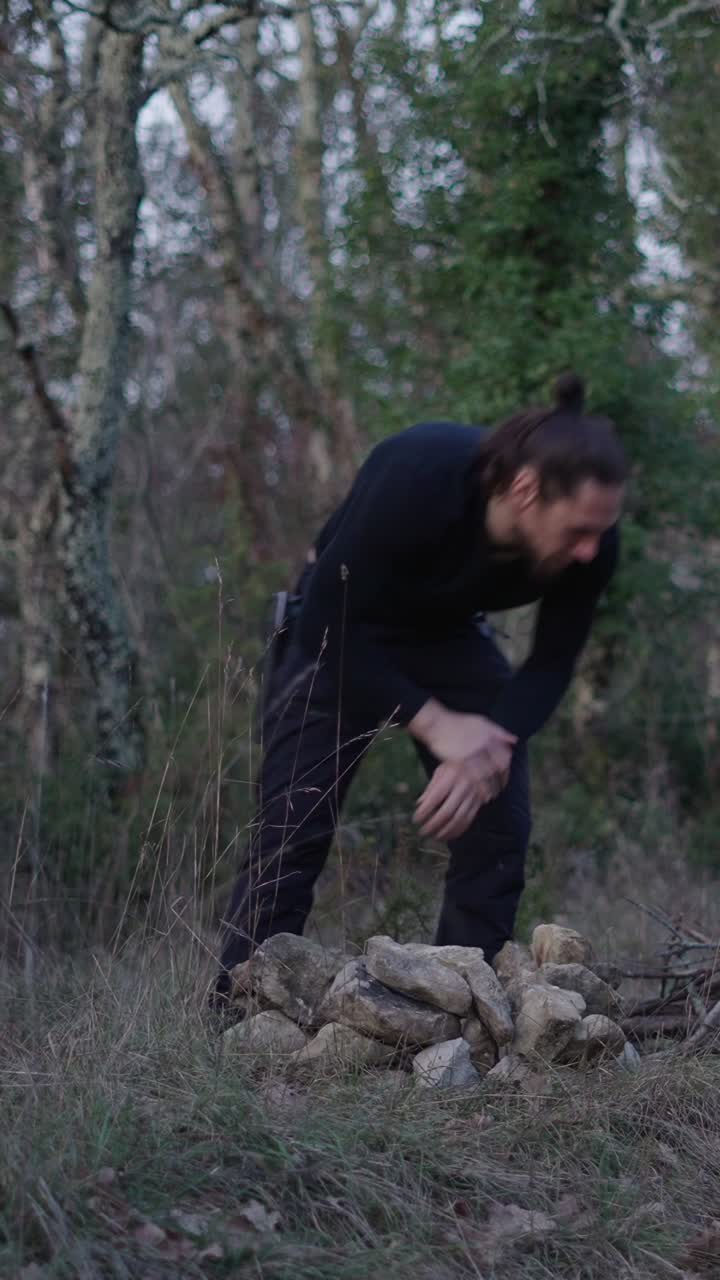 Man stacking rocks in a forest