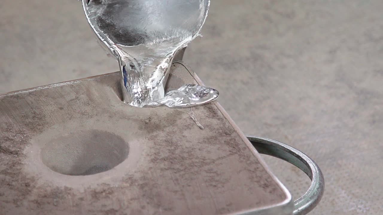 도가니에 액체 금속을 붓는 전체 샷