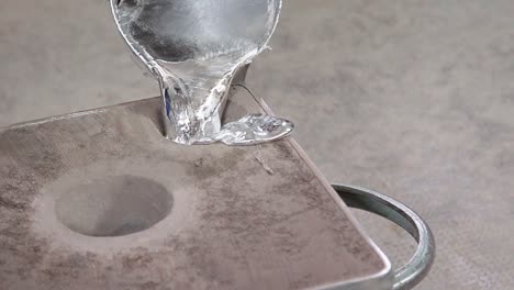 full shot of pouring liquid metal into a crucible