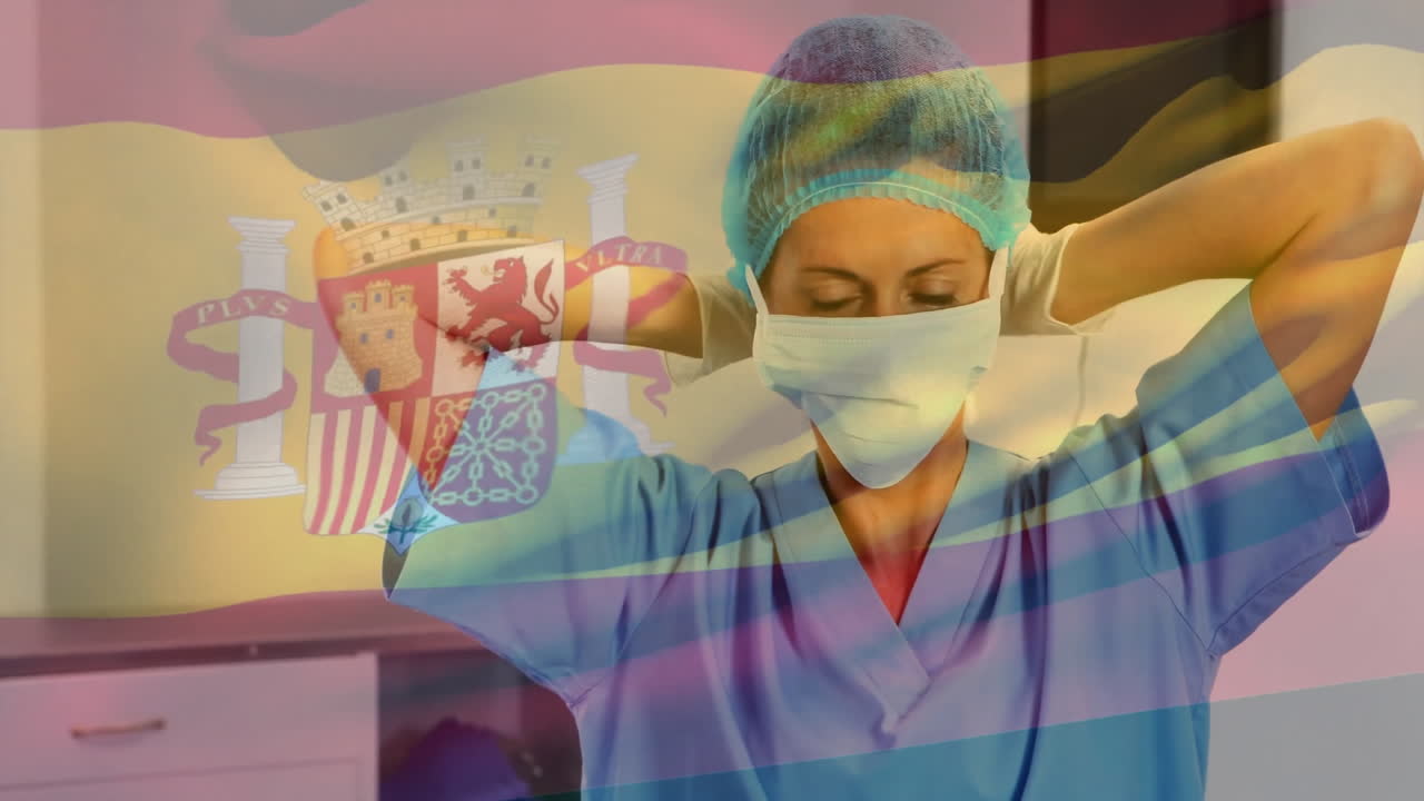 Animation of flag of spain over biracial female surgeon with face mask