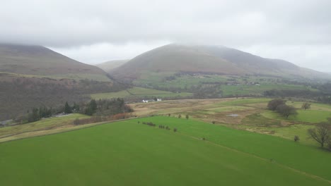 Grüne-Wiesen-Und-Felder-Mit-Blick-Auf-Die-Berge,-Eingehüllt-In-Nebel-In-Keswick,-England,-Großbritannien