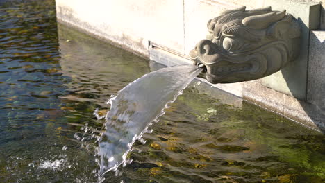 dragon head fountain pouring water in a chinese temple