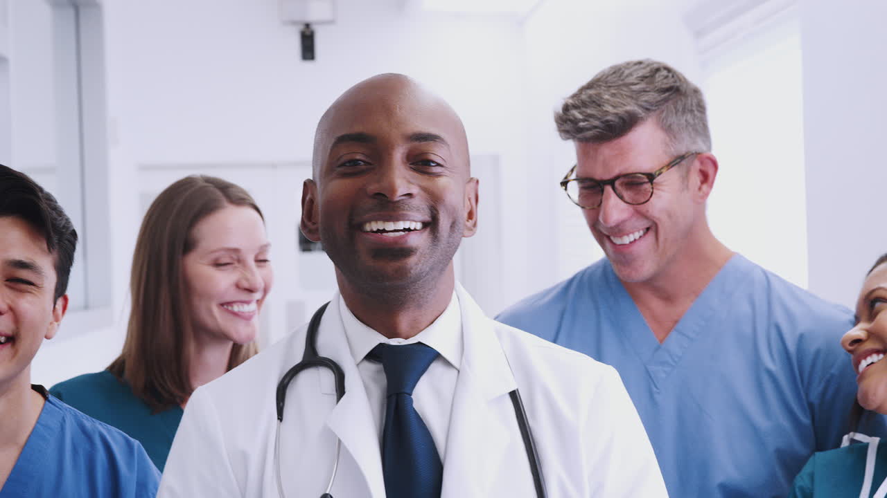 Portrait Of Smiling Multi-Cultural Medical Team Standing In Hospital Corridor