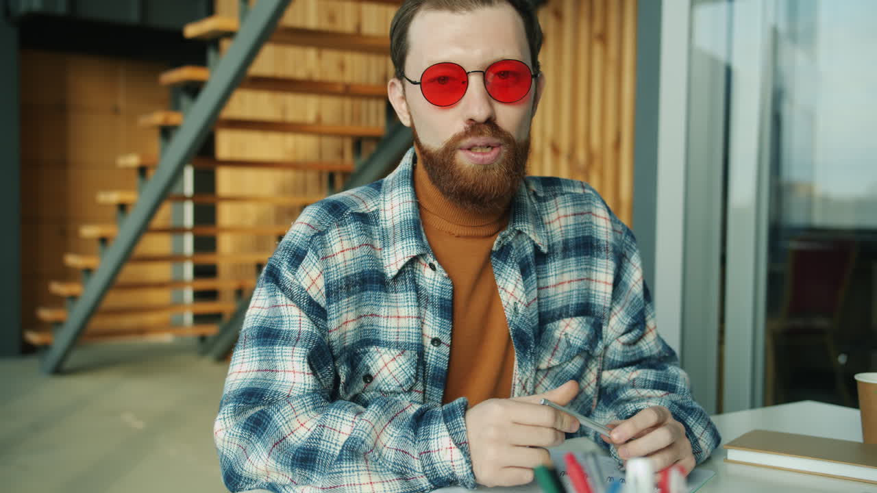 Man with red sunglasses working at a table