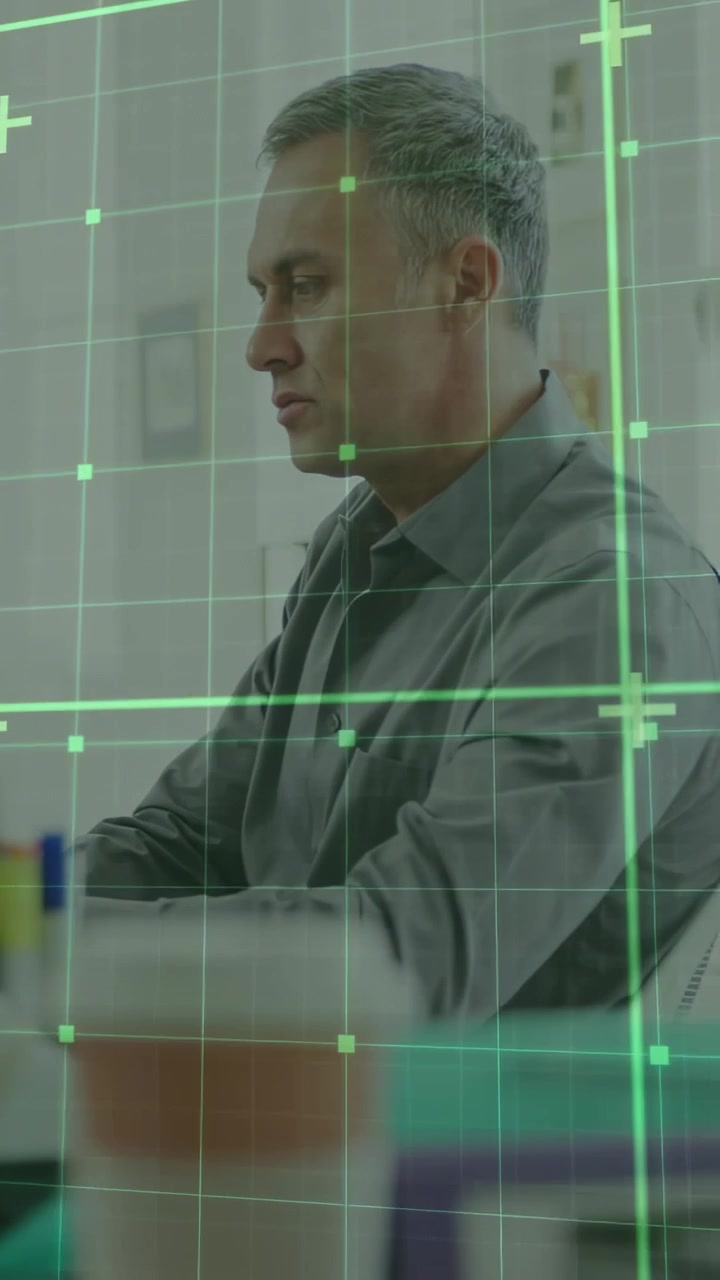 Video verticale: Uomo alla scrivania che controlla documenti mentre una griglia verde attivata dallo schermo esegue una scansione per la finanza.