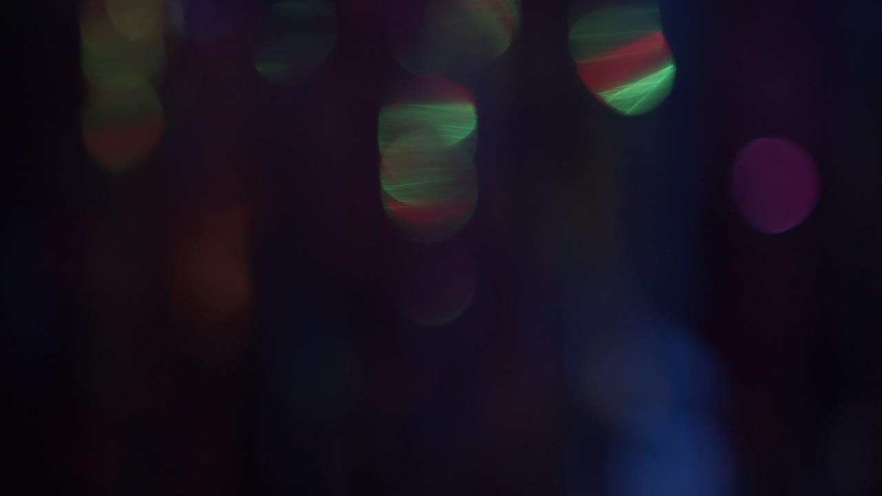 Out of focus curtain glitters in the neon lights