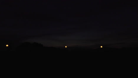 timelapse of the last lights of the day in a small town. the sun illuminates the clouds below leaving beatiful and pink colors