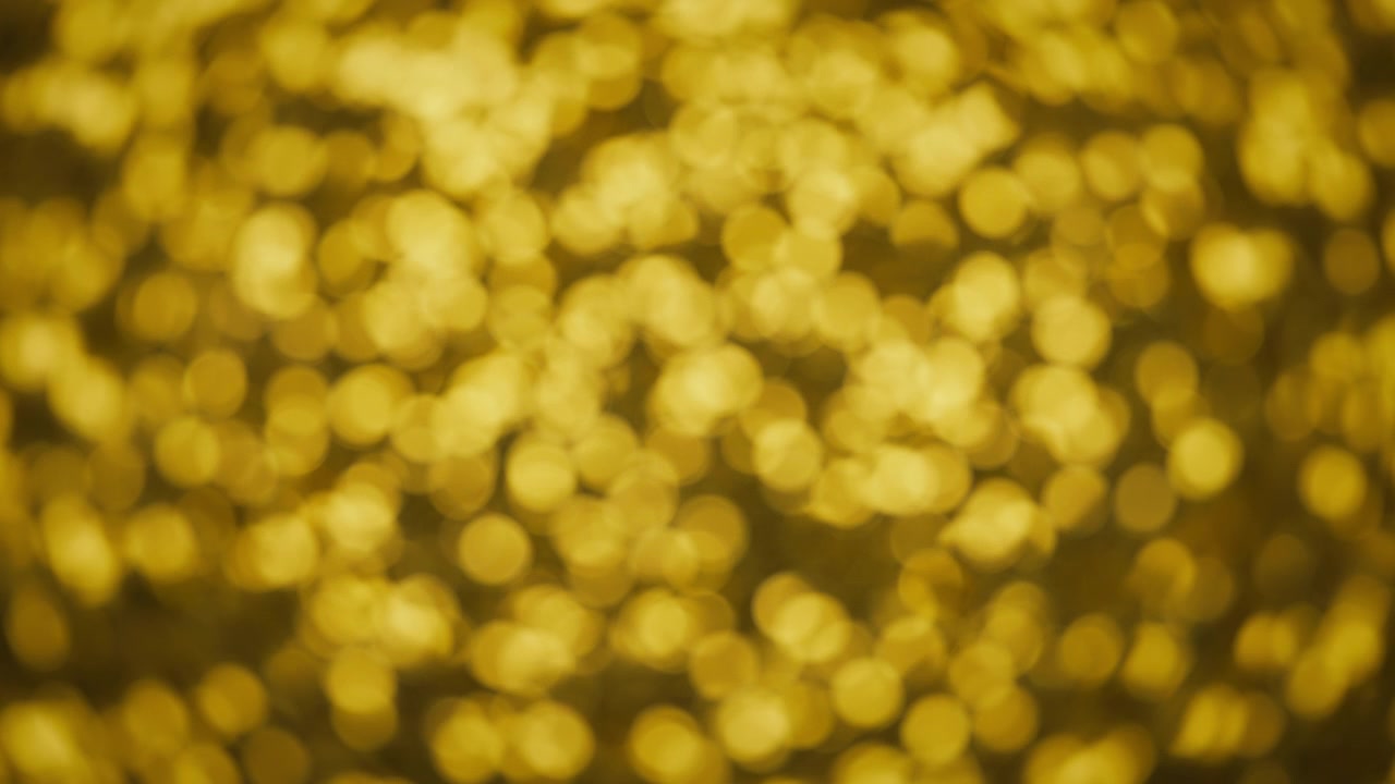 Abstrakt bokeh-bakgrunn av glitrende gyllen glitter.