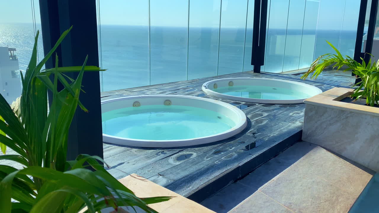 Due vasche idromassaggio Jacuzzi su un tetto di lusso. Vista panoramica sull'orizzonte blu dell'oceano in un resort tropicale. Arredamento di alta gamma