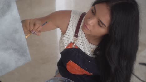 una joven artista inspirada que crea lienzos con pinturas al óleo