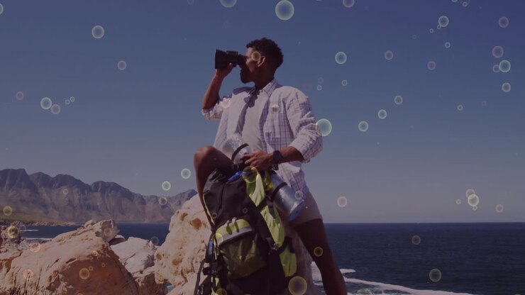 man scanning coastal cliff with binoculars, showing animated graph and compass icons for technology